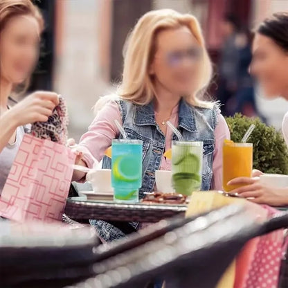 Clear cocktail glasses with lids and straws